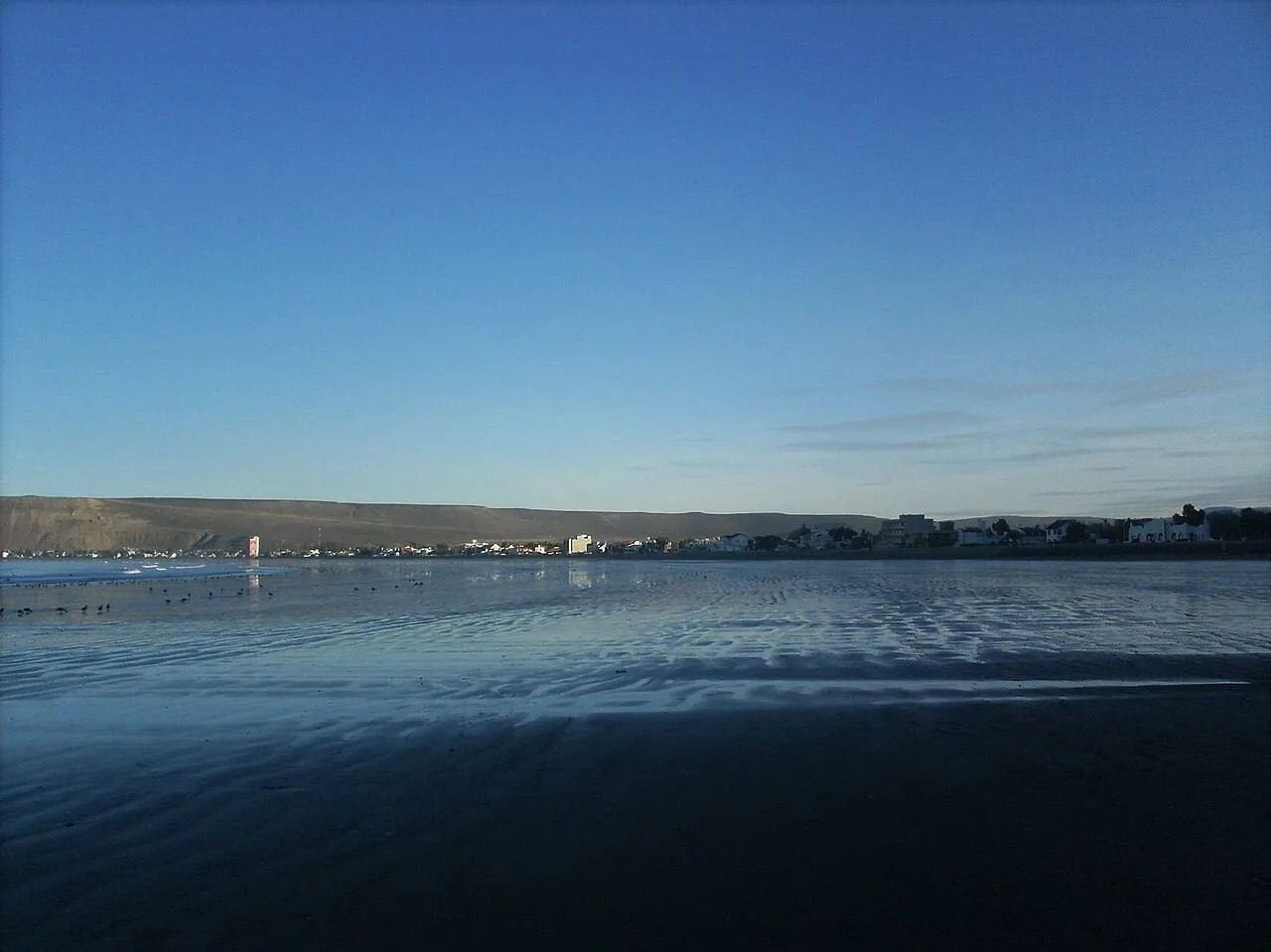 El mar calmo de Rada Tilly con el pueblo al fondo